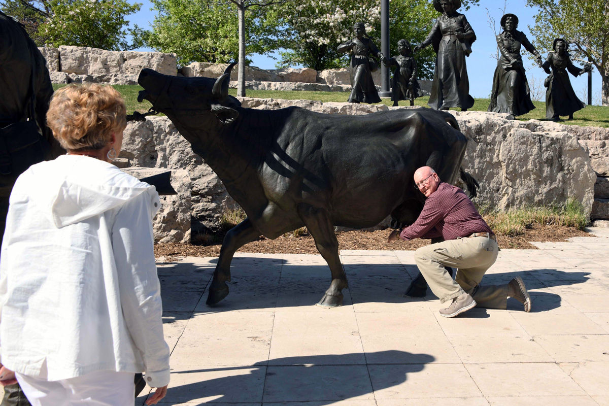 019 Arnie Otten had fun milking the bronze cow.JPG
